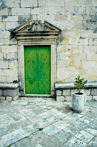 Green door on stone wall. A portal to another world.